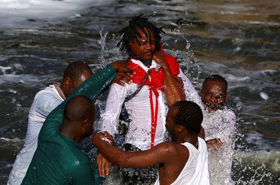 Morian afrikkalaisen kirkon jäsenet kastavat Siboniso Mdakan Kliprivierjoessa Johannesburgin kaakkoisosassa Etelä-Afrikassa.