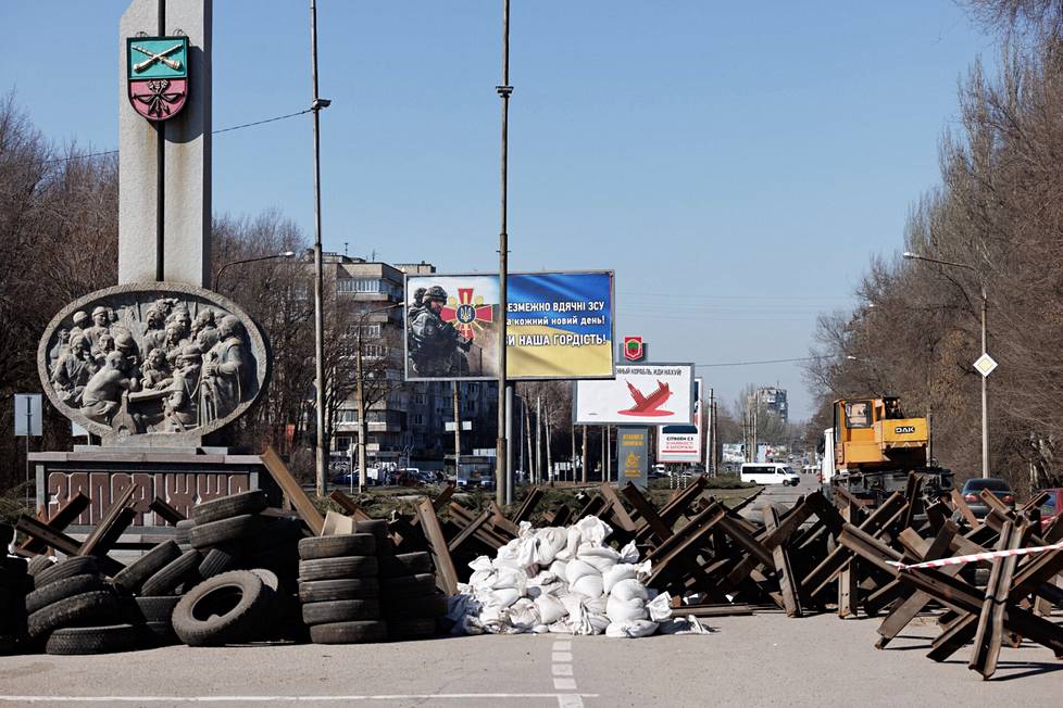 Противотанковые заграждения и агитационные плакаты на улицах Запорожья.