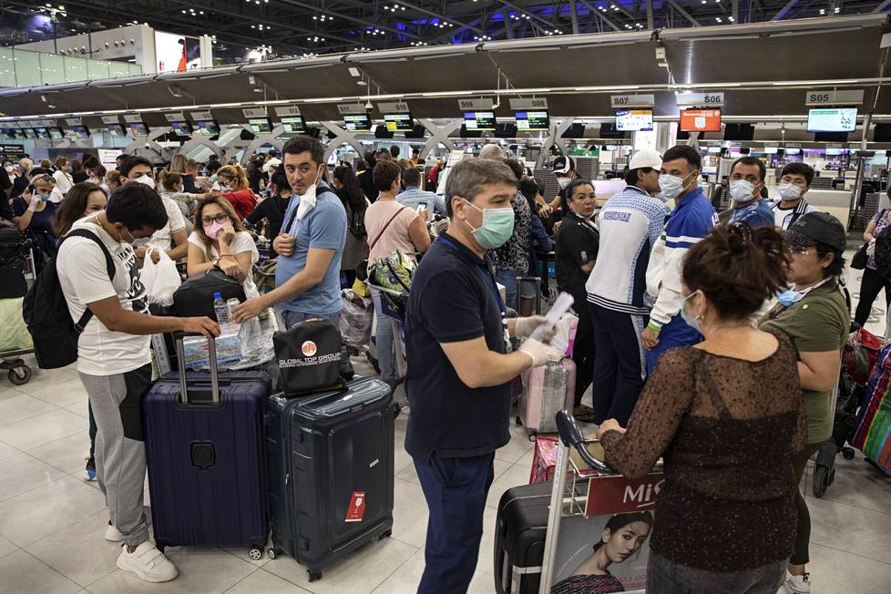 Matkailijat jonottivat Bangkokin lentokentällä viime vuoden maaliskuussa, kun Thaimaa sulki rajojaan koronaviruksen vuoksi.