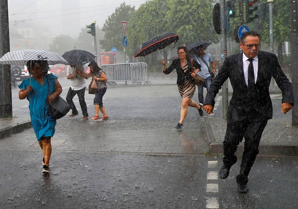 People rushed indoors from heavy rain in June 2018 in Frankfurt, Germany.