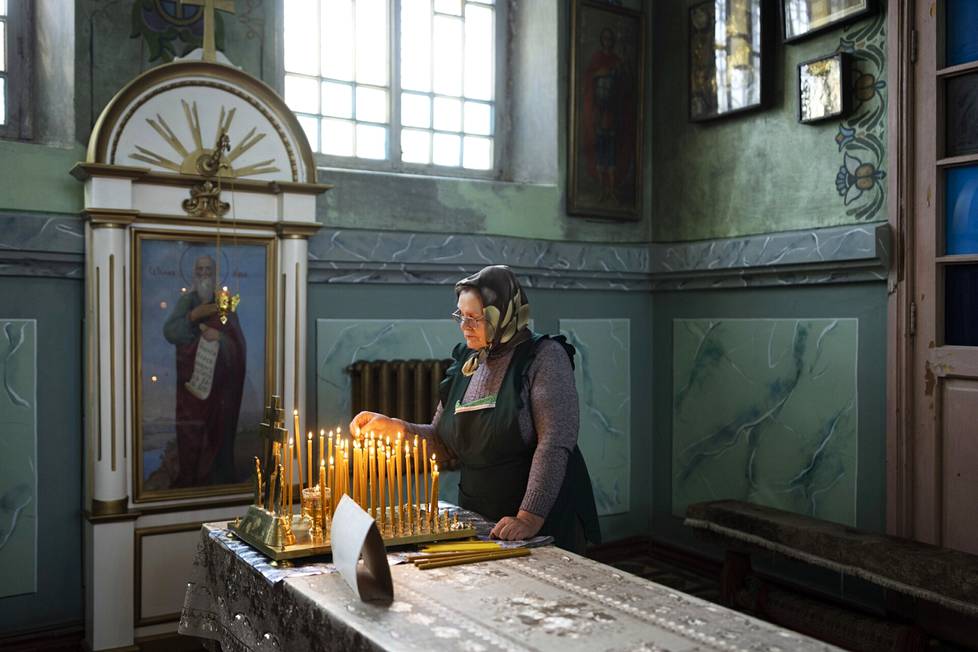 Jaskilainen Elena sytytti kynttilän ja rukoili kirkossa torstaina.