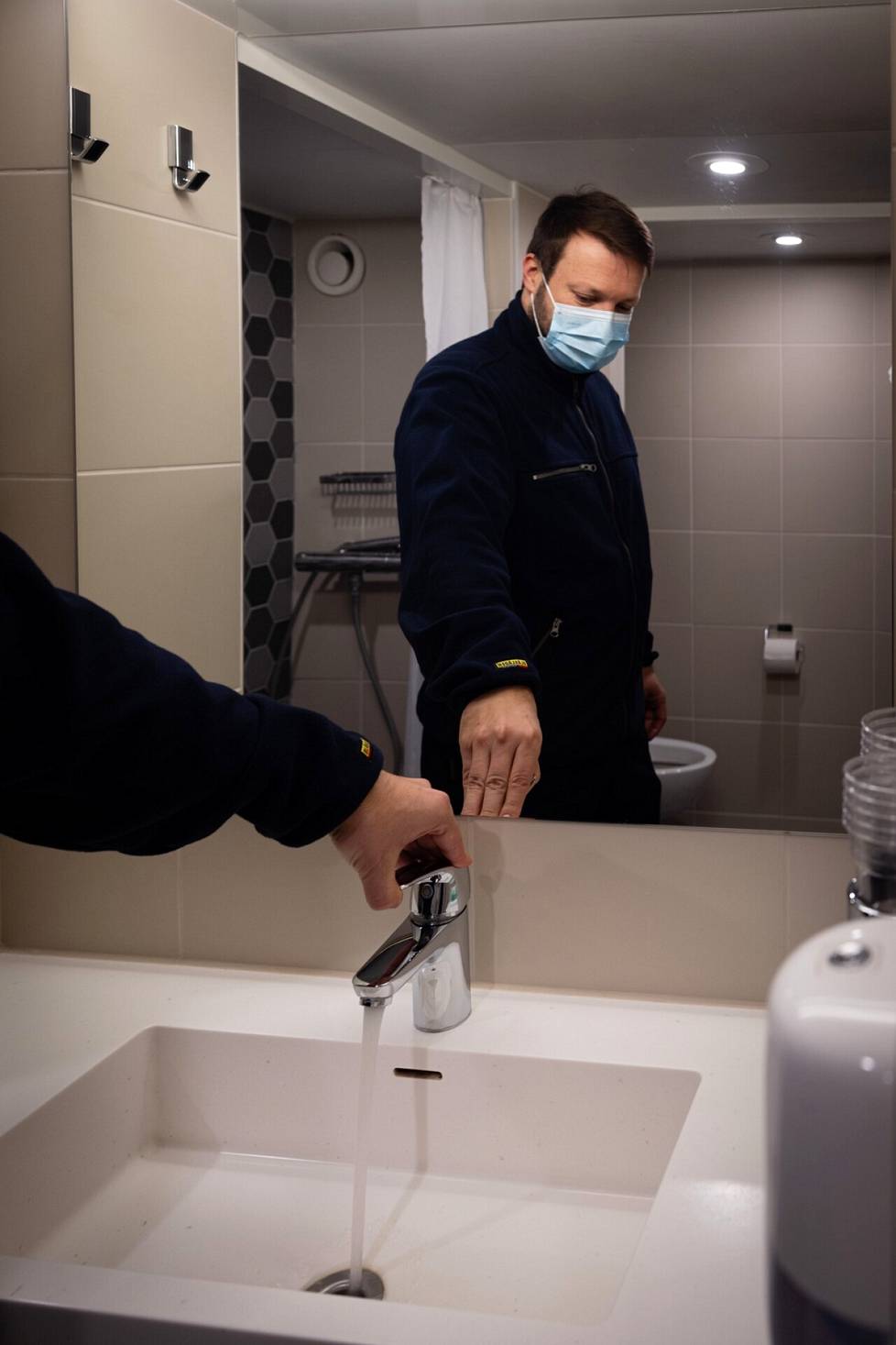 Juha Rauhio, the safety mate responsible for the ship's rescue exercises, runs water in a luxury cabin.  Each of the approximately three thousand faucets must be checked regularly.