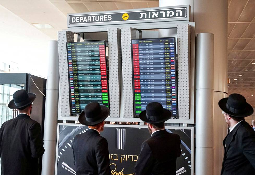 Matkustajat katsovat näytöltä viivästyneitä lentoja Ben Gurionin kansainvälisellä lentokentällä Israelissa. Lentokentän tiedottajan mukaan lentojen lähdöt keskeytettiin maanantaina osana mielenosoituksia.