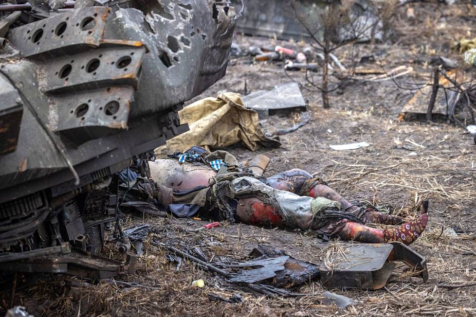Venäläissotilaan ruumis makaa tuhoutuneen panssarin vieressä lähellä Butšaa.
