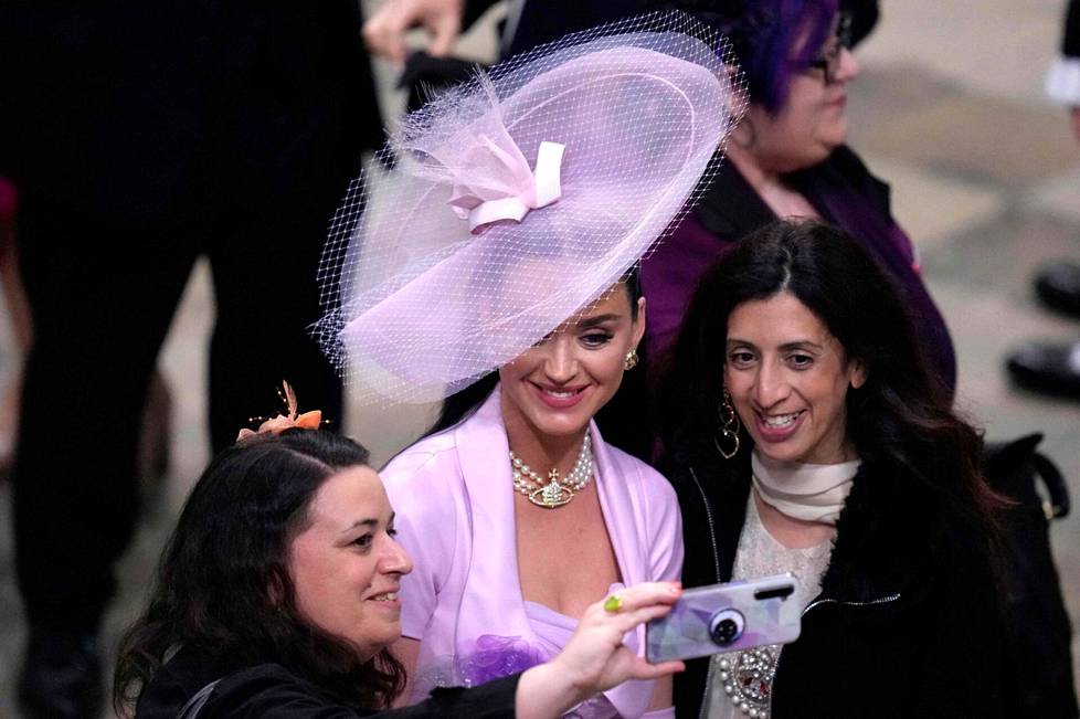 Kruunajaisvieraat ottavat selfieitä kruunajaisiin osallistuneen Katy Perryn kanssa seremonian jälkeen.