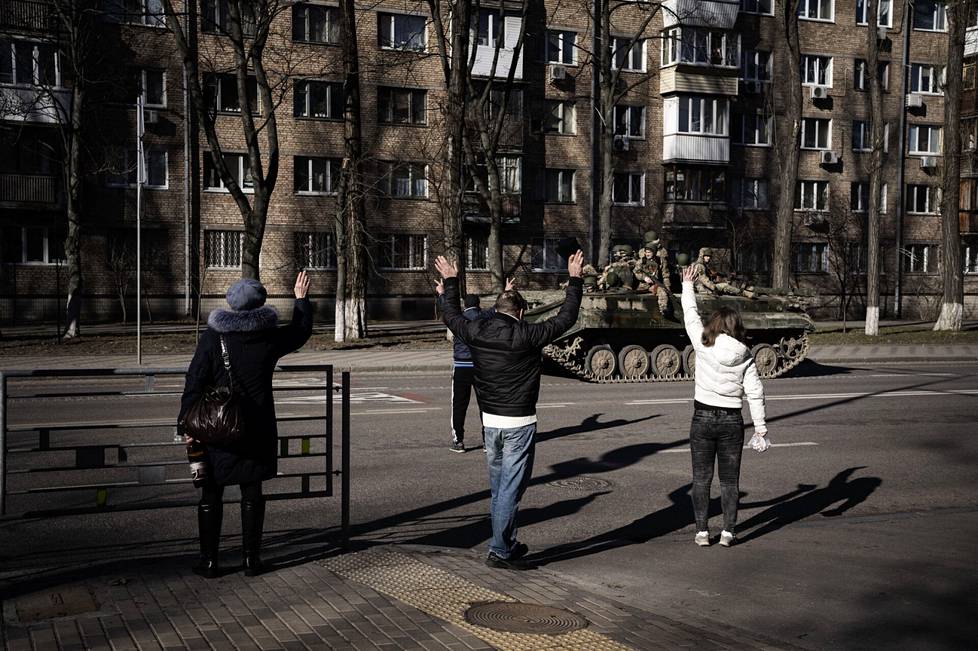 People cheer on the street for a Ukrainian tank.