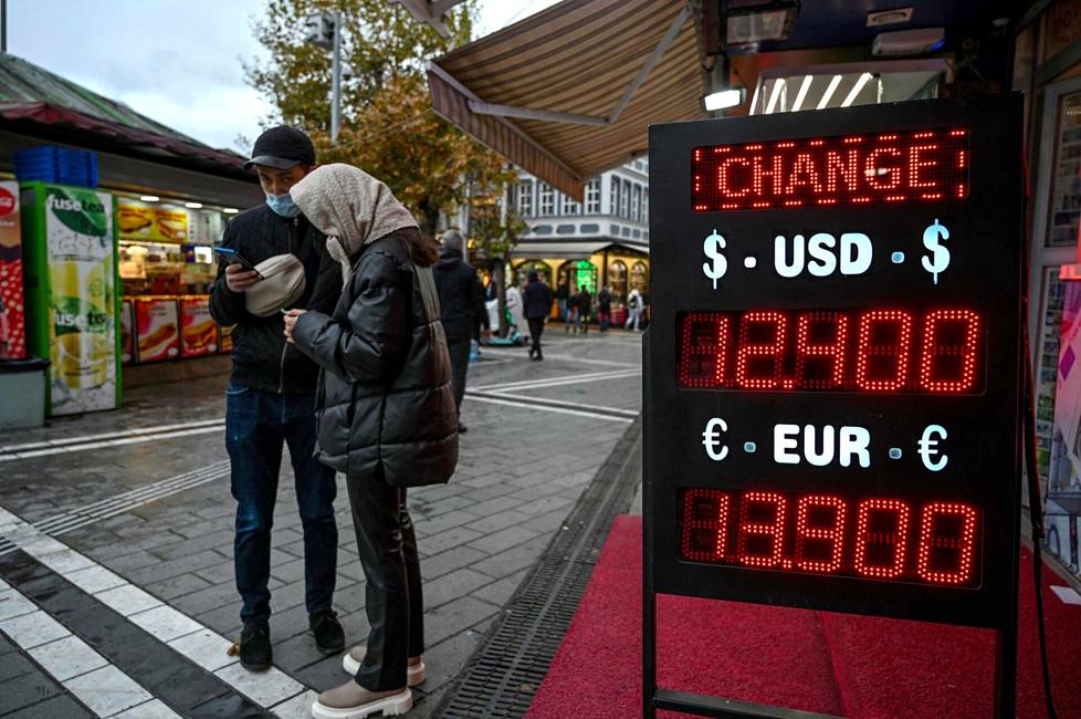 Pariskunta seisoi valuutanvaihtopisteen edessä Istanbulissa 24. marraskuuta. Liiran arvo oli edellisenä päivänä ennätysmäisen heikko.