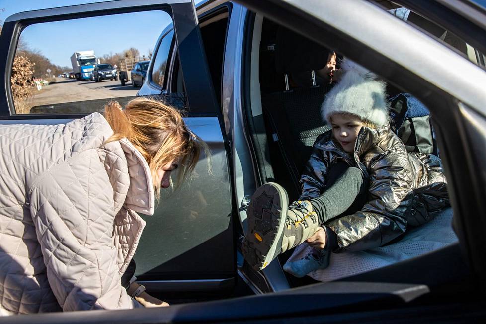 Дочь Фрося снова переодевает запасную одежду и обувь. На заднем плане проезжает длинная вереница машин, покидающих Киев.