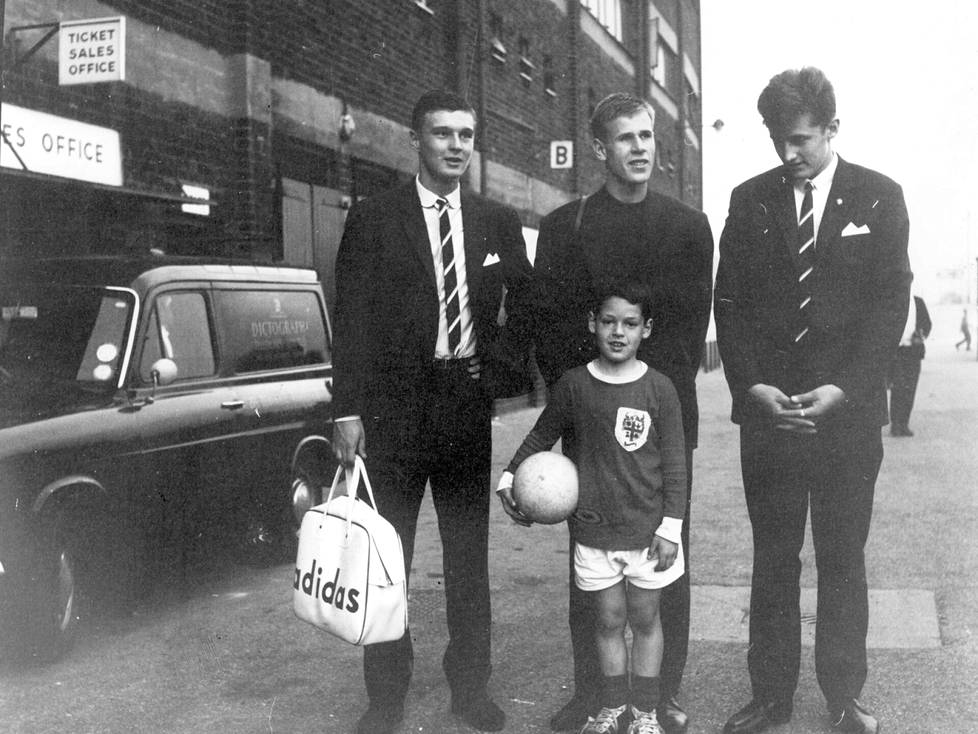 HJK:n pelaajat Markku Peltoniemi, Jarmo Lindahl ja Leo Rislakki poseerasivat Pukevan puvuissaan ja Adidaksen vinyylilaukkujen kanssa yhdessä Unitedin junioripelaaja Keith J. Martinin kanssa Manchesterissa lokakuussa 1965.