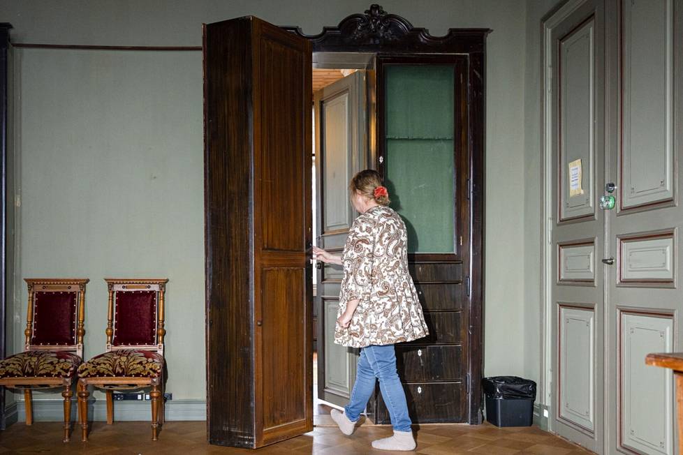 Ulla Kuusimäki avaa asekaapin oven ja astuu takana olevaan huoneistoon, jossa hänen työhuoneensa sijaitsee.