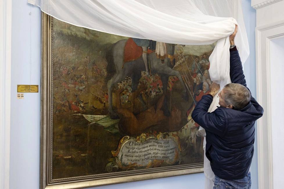 Tutkimusvastaava Serhi Makarenko poistaa suojakangasta Pietari I:tä esittävän maalauksen päältä Pultavan taistelun museossa.