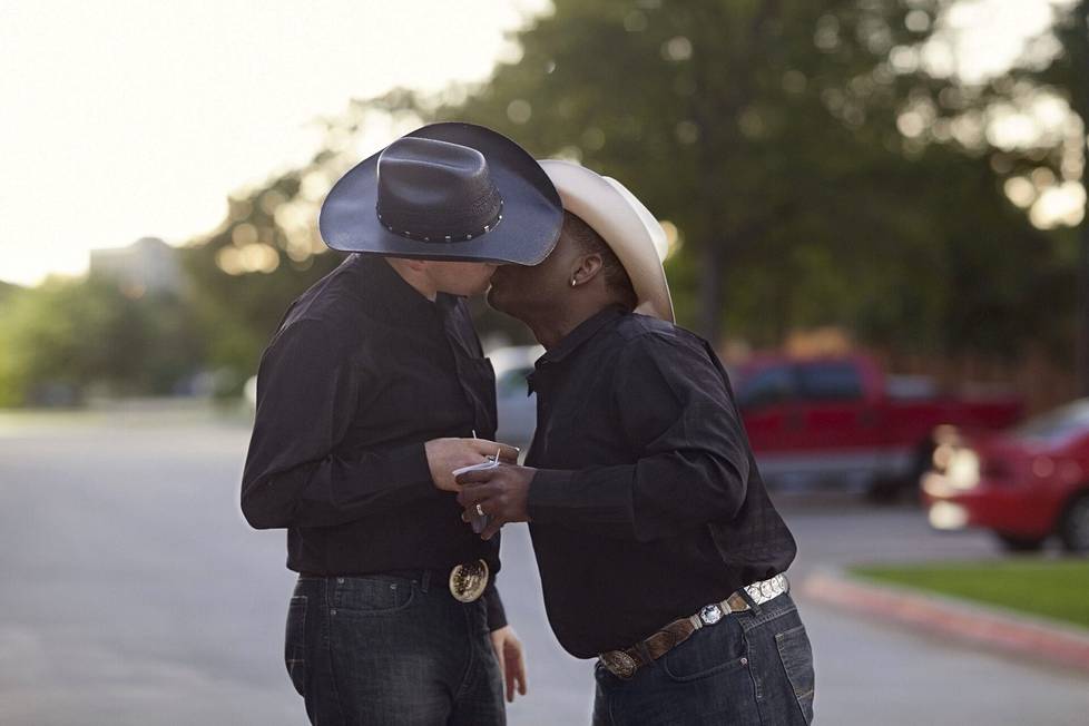 A kiss (Robert & Troy). International Gay Rodeo Finals, Fort Worth, Texas 2012. Karoliina Paatos: ”Jututin ja kuvasin tätä pariskuntaa Texasissa rodeotapahtuman hotellin pihalla. He eivät osallistuneet kisaan, mutta olivat tulleet katsomaan. He eivät ole itselleni niin läheinen pariskunta, mutta kuvausprojektin kannalta tämä oli tärkeä kuva – aloin ajatella, että kyllä tästä jotain tulee.”