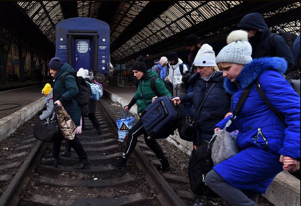 Kotiseuduiltaan sotaa paenneet ihmiset ylittivät junaraiteen Lvivin rautatieasemalla.
