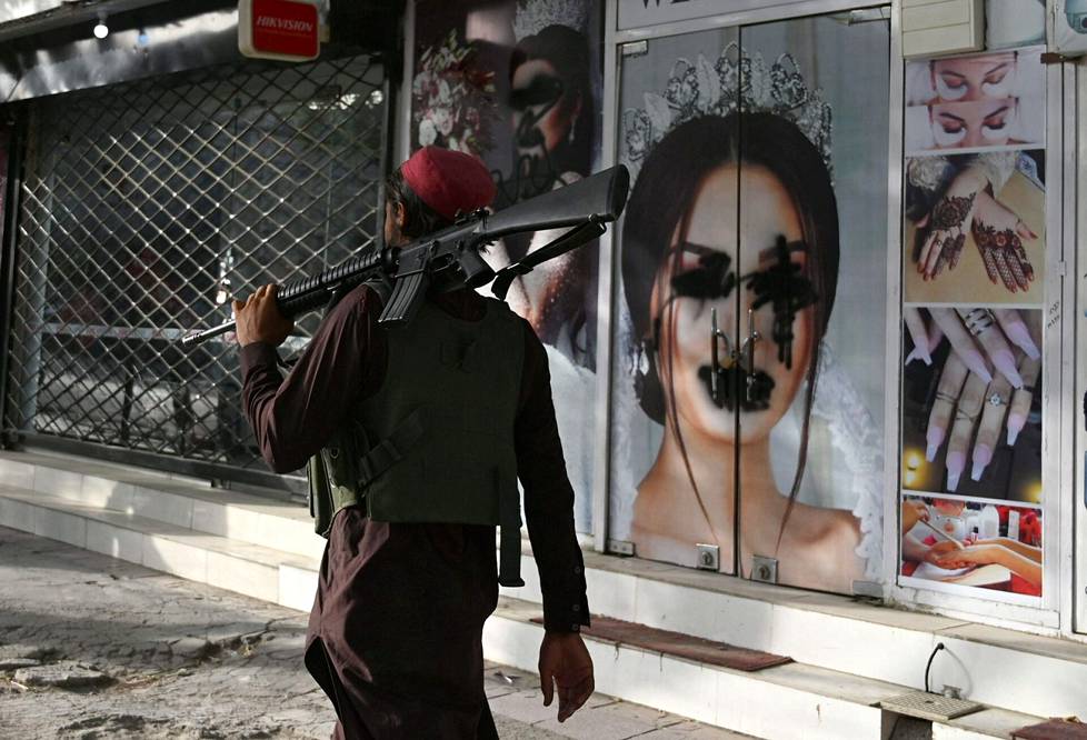 Taleban-sotilas kulki sotketun naisen kuvan ohi Shar-e-Nawin alueella elokuun puolivälissä.