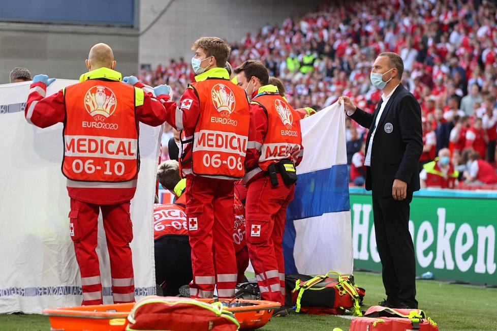 Joukkuetoverit ja hoitohenkilöstö ympäröivät tapahtumapaikan kentällä, kun Christian Erikseniä elvytettiin kesken EM-ottelun. Myös Suomen lippua käytettiin näkösuojana.