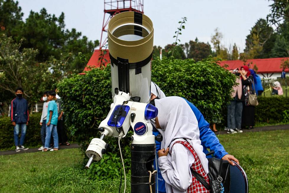 Opiskelijat katsovat osittaista auringonpimennystä kaukoputken läpi Bosschan observatoriossa Bandungissa.