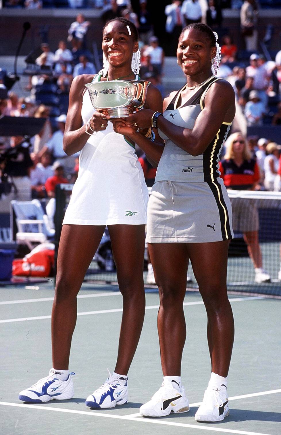 Serena (oik.) ja Venus Williams juhlivat nelinpelin mestaruutta US Openissa vuonna 1999.