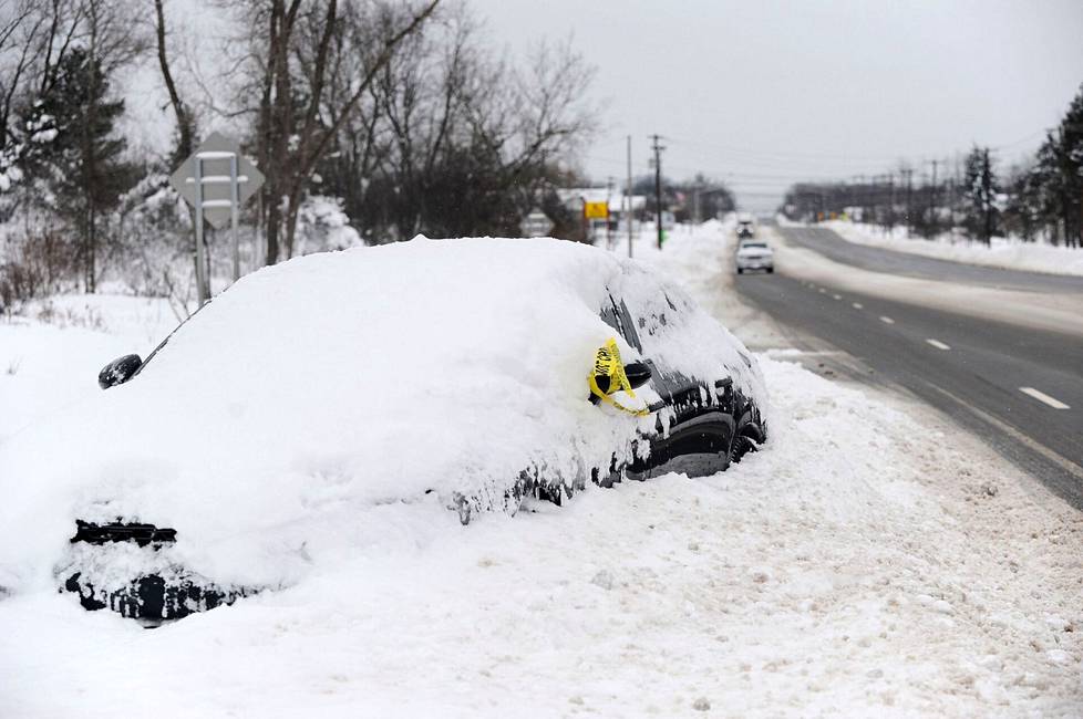 Lumeen hautautunut auto tienvarressa West Senecassa, New Yorkissa maanantaina. 