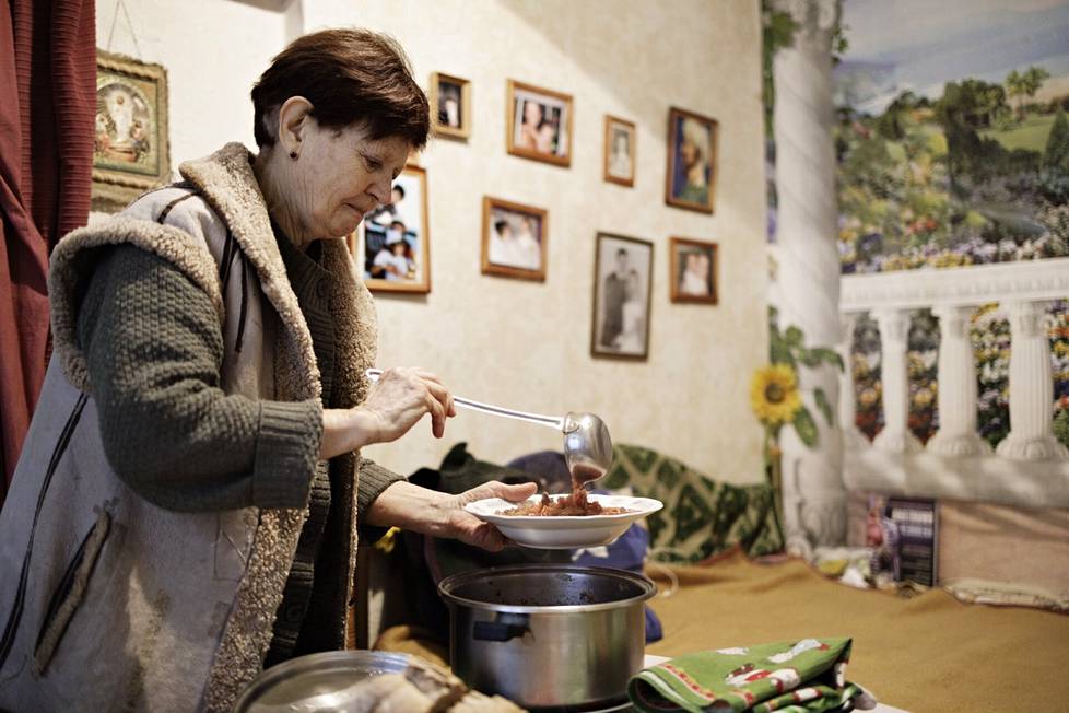 Julia Martšenko annostelee borssikeittoa lautaselle.