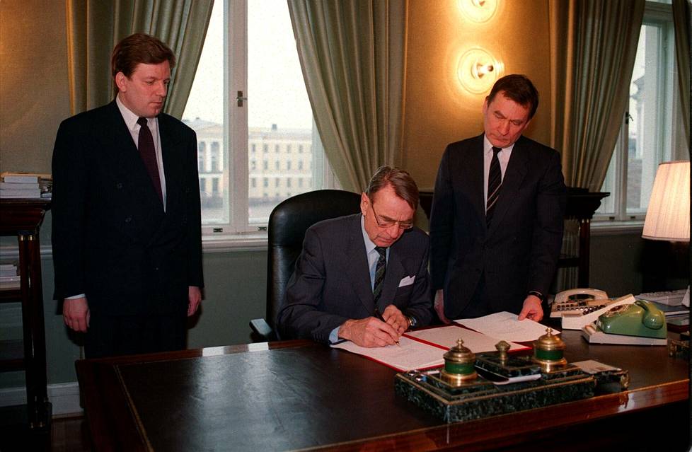 Tasavallan presidentti Mauno Koivisto allekirjoitti Suomen EY-jäsenhakemuksen (EU) maaliskuussa 1992. Pääministeri Esko Aho ja kauppa- ja teollisuusministeri Pekka Tuomisto seurasivat historiallista tilannetta. 