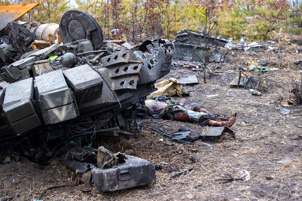 A fallen Russian soldier lies by the destroyed armor.