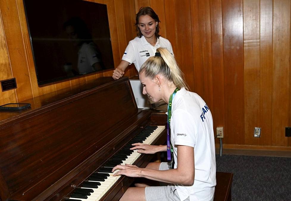 Kristiina Mäkelä soitti pianolla klassista musiikkia Suomen joukkueen tiedotustilaisuudessa. Senni Salminen kuunteli vierellä. 