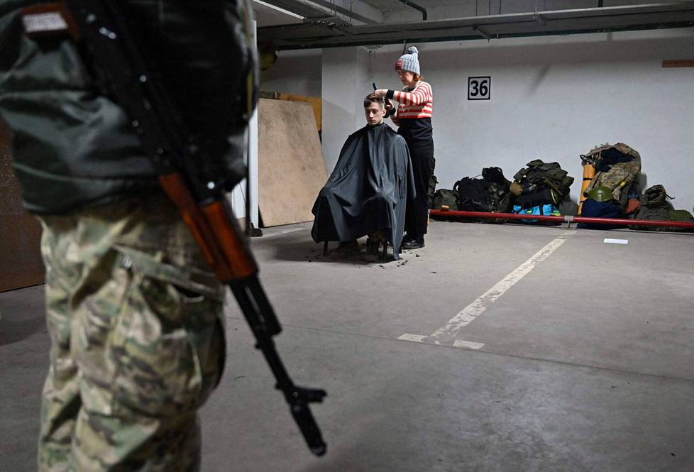 Sotilaan tukkaa leikattiin armeijan käyttöön otetussa parkkihallissa Kiovassa.