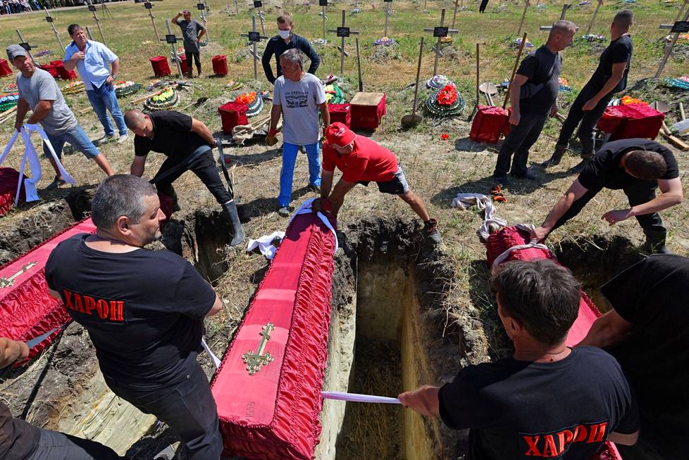 58 tunnistamattomaksi jääneen Luhanskin ”kansantasavallan” sotilaan arkkuja laskettiin hautajaistilaisuudessa Luhanskissa Ukrainassa 12. heinäkuuta.