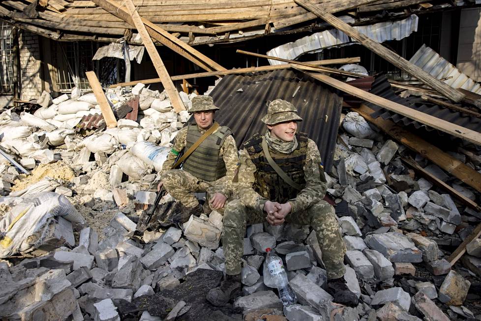 Artjom Puškarjov (oik.) ja Andri Šalja poseeraavat vaurioituneen rakennuksen edessä.