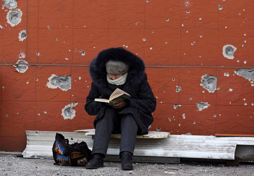 Nainen luki kirjaa Mariupolissa sunnuntaina.