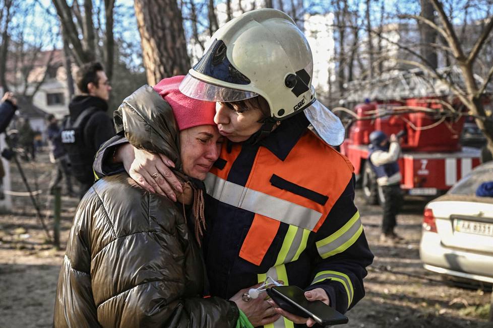 Pelastushenkilökunnanjäsen lohdutti kerrostalosta pelastettua naista Kiovassa.