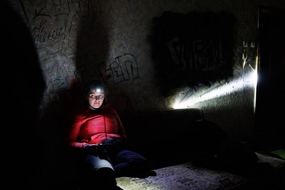 Ukrainalainen mediatyöläinen Jelyzaveta Kovtun työskenteli otsalampun valossa  lämmittämättömässä ja sähköttömässä asunnossa Hersonissa viime viikon perjantaina.