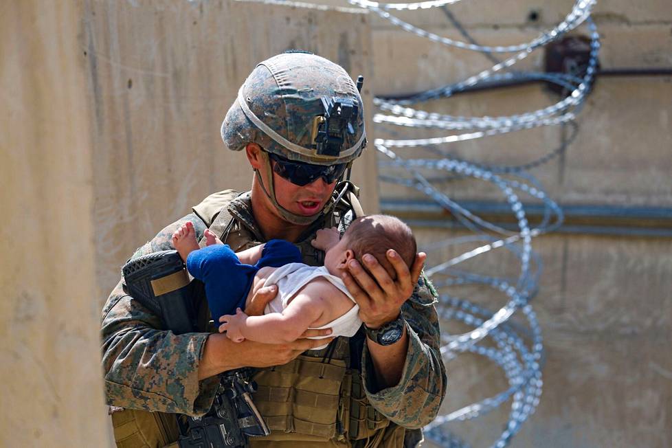 Yhdysvaltojen merijalkaväen sotilas piteli afganistanilaista lasta Kabulin lentokentällä 21. elokuuta.