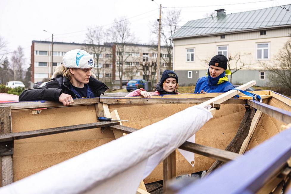 Matias Fahllund, Katie Astin ja Ville Väänänen ihailevat venettään.
