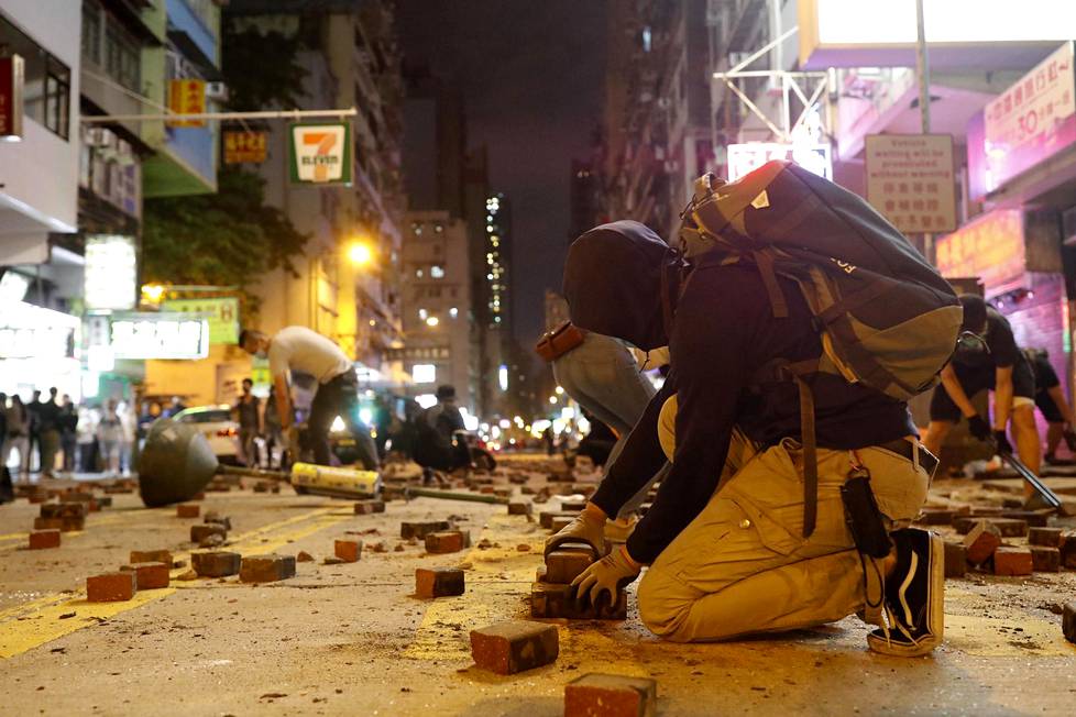Mielenosoittajat repivät maanantaina Hongkongin kaduilla irti katukiviä ja levittivät niitä kaduille, jotta autot eivät pääsisi ajamaan kunnolla.