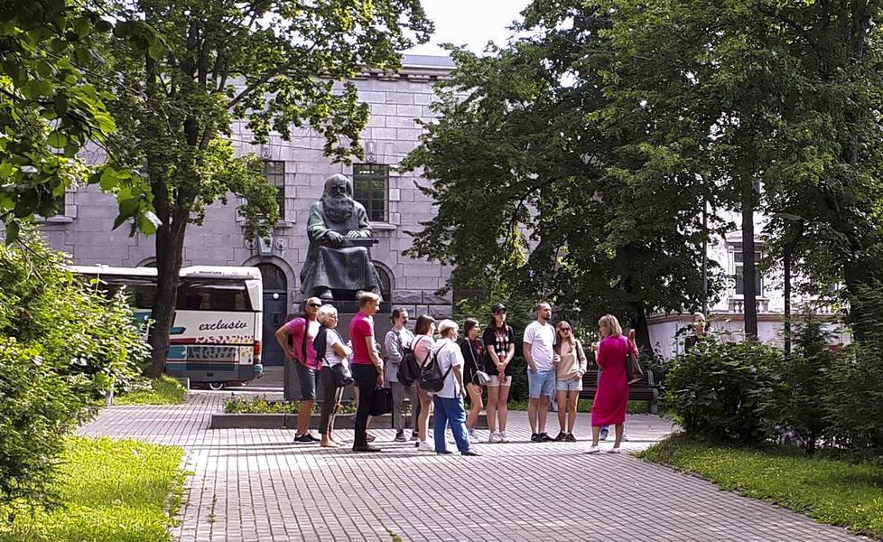 Venäläinen turistiryhmä Sortavalassa kesällä 2022. Taustalla Alpo Sailon veistämä Runonlaulajan patsas, joka pystytettiin vuonna 1935.