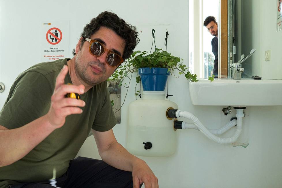 Sergio Rodríguez näyttää, miten käsienpesuvesi kierrätetään viherkasvien kasteluun. Adrian Jiménez kurkki taustalla. 
