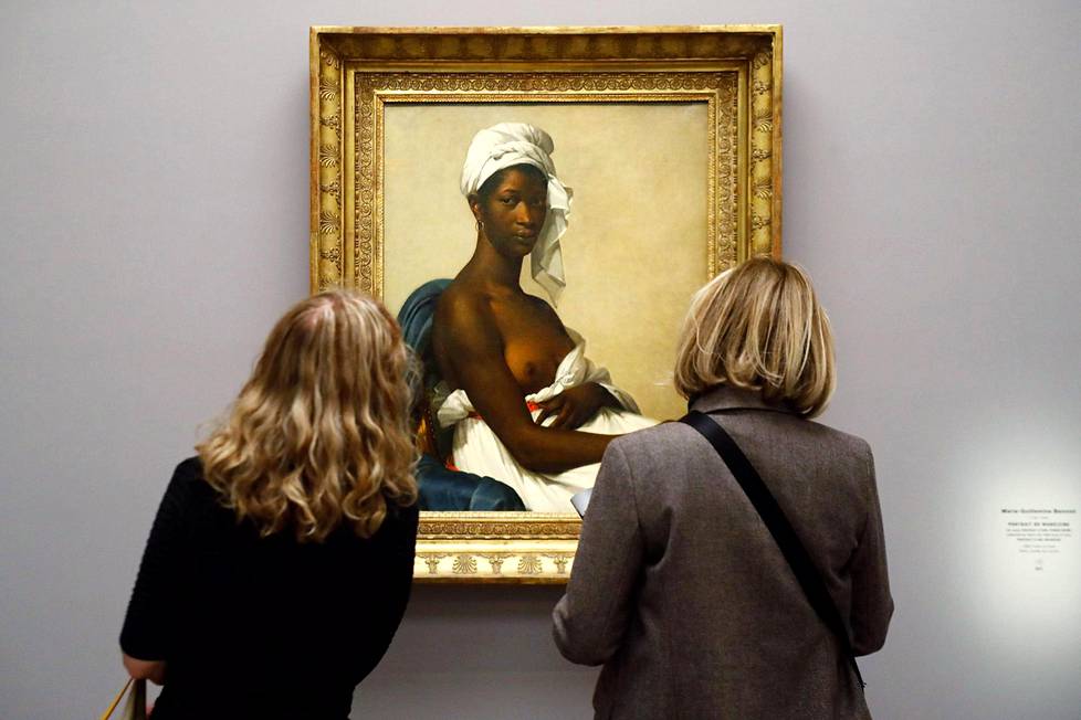 Näyttelyvieraat katselevat Marie-Guillemine Benoist’n maalausta  Mustan naisen muotokuva  (1800).