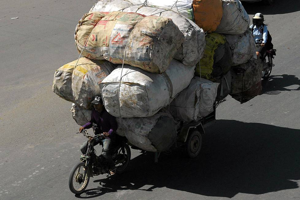 Mies kuljetti kierrätysmateriaalikuormaa Kambodžan pääkaupungissa Phnom Penhissä tiistaina. Maan viranomaisten mukaan teillä kuolee vuosittain noin 1 900 ihmistä ja loukkaantuu yli 14 000.