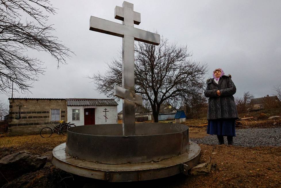 Paikallinen asukas Vera Barda, 74, seisoo tyttärentytärtänsä talossa sijaitsevan kappelin ulkopuolella ortodoksisen jouluaaton jumalanpalveluksen aikana Volnovahan kaupungissa, 6.tammikuuta.
