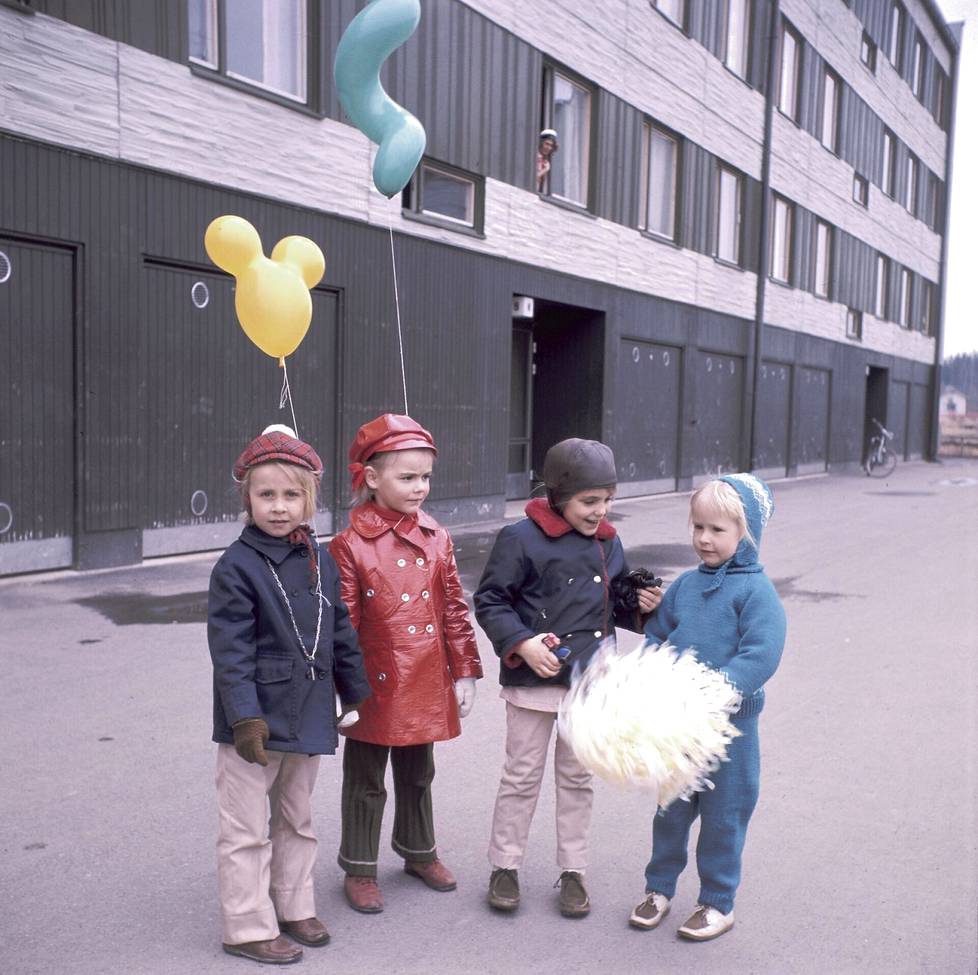 Pienet ystävättäret Kirsi Jalava, Janine Tourneur, Liisa Hako ja Marita Perälä vappuna 1970. Ikkunassa louhelalaisen Hakojen perheen äiti Airi Hako. Louhela– Ihmisen kokoinen -kirjan kuvitusta. 