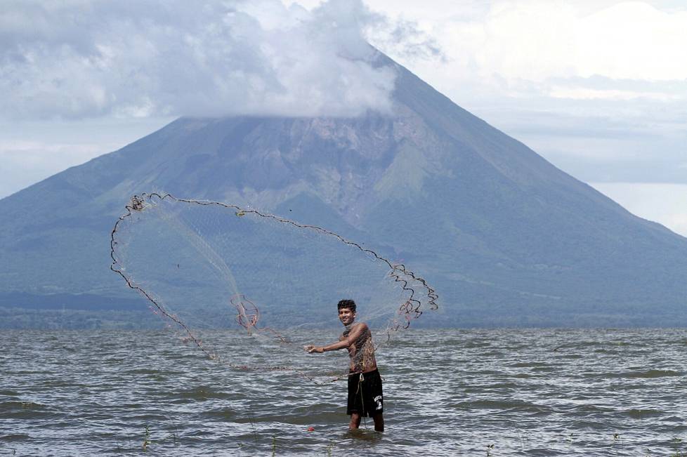 Kalastaja heitti verkkoa Nicaraguajärvellä, jonka kautta kanava kulkisi Atlantilta Tyynellemerelle. Taustalla näkyy tulivuorisaari Ometepe. Kuva on vuodelta 2014, jolloin hankkeen lupailtiin turhaan etenevän.