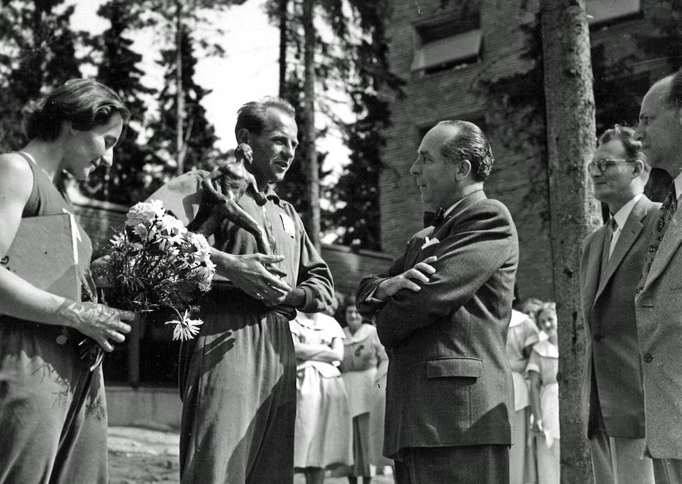 Helsingin olympialaiset vuonna 1952. Tähtiurheilija Emil Zátopek saa Nurmi-patsaan Otaniemen Teekkareilta. Lahjan ojentajana oli yli-insinööri Ilmari Harki.