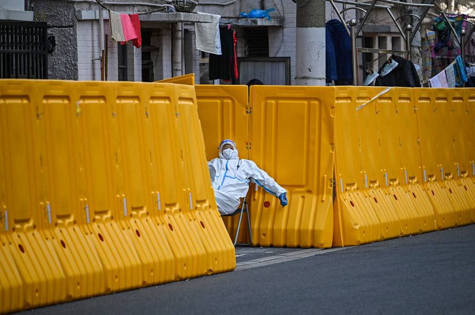 29. maaliskuuta. Työntekijä vartioi suljetun kaupunginosan sisäänkäyntiä Jinganin alueella Shanghaissa, Kiinassa. Kaupunginosa suljettiin koronatartuntojen vuoksi.