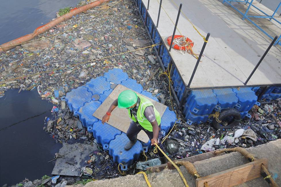 Suomalaisen Riverrecycle-yrityksen intialainen työntekijä lajitteli Mumbaita halkovasta Mithijoesta kerättyä roskaa tiistaina.