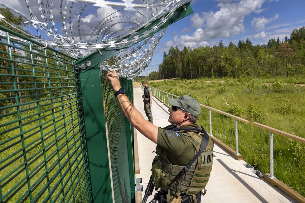 Virolaiset rajavartijat Kaimar ja Ivo partioivat vastavalmistuneen raja-aidan vierustalla heinäkuussa 2022. Ivo sanoo, että työ on aidan rakentamisen myötä helpompaa muun muassa, koska rajan ylittäminen kestäisi pidempään. 