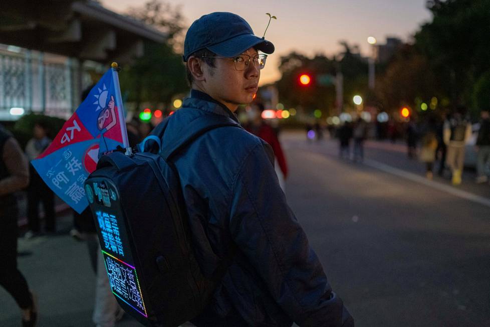 Engineer Jacky Hsiao, 30, made himself a screen in his backpack that repeats slogans supporting Ko Wen-jen.  Ko is on the side of science and does not leave children with debts, Hsiao believes.  