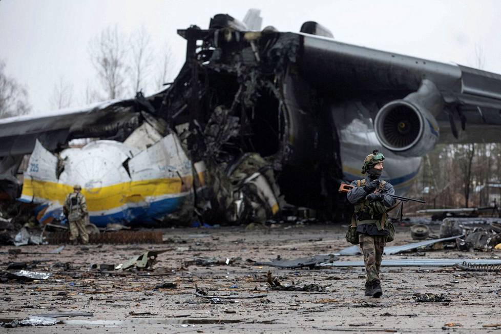 Ukrainalaissotilas partioi Hostomelin lentokentällä, joka ollut venäläisjoukkojen hallussa. Taustalla näkyy tuhoutunut Antonov An-225 ”Mrija”, maailman suurin käyttöön päässyt lentokone, 6-moottorinen rahtikone.