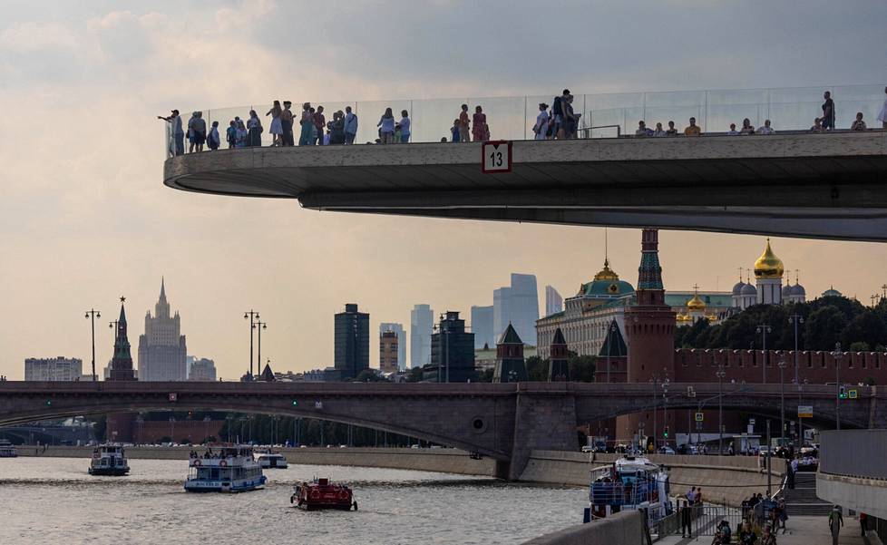 Ihmiset katselivat jokimaisemia ja Kremlin kupoleja näköalatasanteella Moskovassa elokuun alussa.