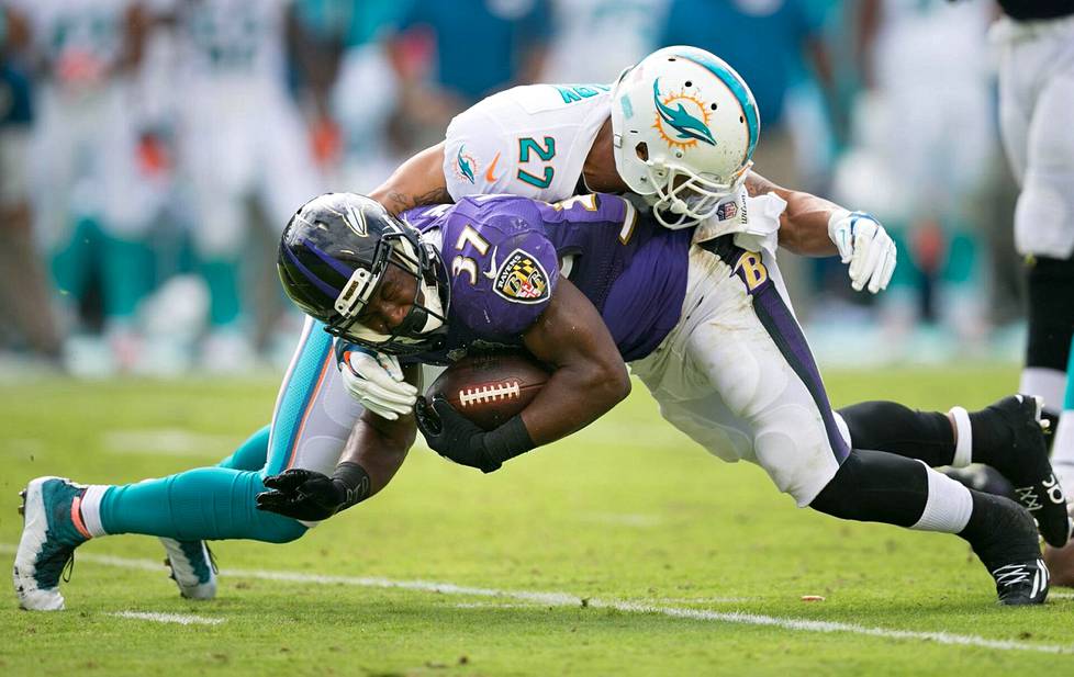 Miami Dolphinsin Shamiel Gary (27) taklaamassa Baltimore Ravensin Javorius Allenia Miami Gardensissa pelatussa ottelussa joulukuussa 2015.